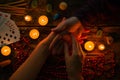 Fortuneteller reads fortunes by hand on a background of candles and runes