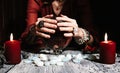 Fortuneteller& x27;s hands on a glass orb. Prediction of the future. Mystic interior. Occult symbols, runes stones, candles