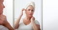 Forty years old woman looking at wrinkles in mirror. Plastic surgery and collagen injections. Makeup. Macro face Royalty Free Stock Photo