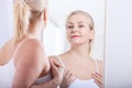 Forty years old woman looking at wrinkles in mirror. Plastic surgery and collagen injections. Makeup. Macro face. Selective focus Royalty Free Stock Photo