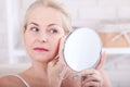 Forty years old woman looking at wrinkles in mirror. Plastic surgery and collagen injections. Makeup. Macro face Royalty Free Stock Photo