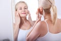 Forty years old woman looking at wrinkles in mirror. Plastic surgery and collagen injections. Makeup. Macro face Royalty Free Stock Photo