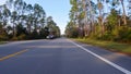 Forward driving plate on small highway bordered by pint trees