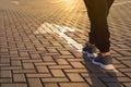 Forward moving. Feet on road arrow in the rays of setting sun