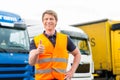 Forwarder or driver in front of trucks in depot Royalty Free Stock Photo