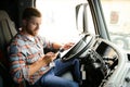 forwarder driver sits behind the wheel of a car and examines waybills documentation for the cargo. Royalty Free Stock Photo