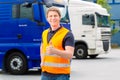 Forwarder in front of trucks on a depot Royalty Free Stock Photo