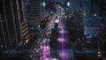 Forwards fly above thoroughfare in modern metropolis at night. Queue of cars at traffic lights. Jakarta, Indonesia