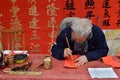 FOSHAN, CHINA - CIRCA JANUARY 2020: A man writing blessing antithetical couples during the Spring Festival. Royalty Free Stock Photo