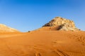 Fossil Rock limestone rock formation in the desert, with sand dunes and tire tracks around, Sharjah, United Arab Emirates Royalty Free Stock Photo