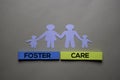 Foster Care text on sticky notes with house and family made in paper on office desk Royalty Free Stock Photo