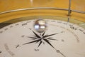 Foucault pendulum swinging on a compass rose. Pendulum blurred by movement. The text in latin