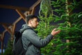 Found perfect Christmas tree bought at special planting place. Young adult man choosing a Christmas tree. Male buying christmas Royalty Free Stock Photo