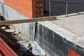 Foundation Waterproofing and Damp proofing Coatings.Waterproofing house foundation with spray on tar. Royalty Free Stock Photo