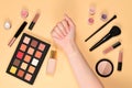 Foundation on woman hand. Professional makeup products with cosmetic beauty products, foundation, lipstick, eye shadows, brushes