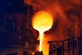 Foundry cast iron production. Molten metal pouring from ladle into mould Royalty Free Stock Photo