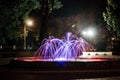 a fountain with a beautiful backlight litm in the park