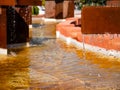 Fountain with brick edges with metal structures that make beautiful water drop curtains