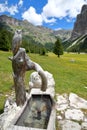 A fountain with a carved wooden owl along Vallunga Valley above Selva, Val Gardena