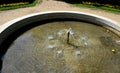 Edge of a stone sandstone circular fountain in the park. built of sandstone filled with water. lined with a light threshing gravel Royalty Free Stock Photo