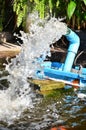 A fountain that comes out of a blue pipe to oxygenate the fish in the park. Royalty Free Stock Photo