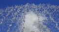 Fountain drops of pure water against a blue sky. Royalty Free Stock Photo