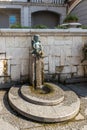 A fountain in the form of a cupid sitting on a pedestal in the Batumi Piazza square in the old part of the Batumi city - the