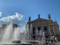 Fountain in front of the classical opera house in Lviv, opera theater building with columns and sculptures on the roof