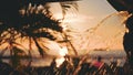 Fountain with golden water. The leaves of a coconut tree sway in the wind against the blue sky at sunset. Incredibly Royalty Free Stock Photo