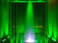 Fountain, green illuminated flowing water by night, abstract, background