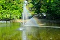A fountain gushing water over a lake against a background of green trees. Royalty Free Stock Photo