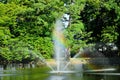 A fountain gushing water over a lake against a background of green trees. Royalty Free Stock Photo