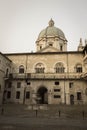 Fountain in the inner yard of medieval palace Palazzo del Broletto with dome of the New Cathedral on background, Brescia, Lombardy