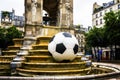 Fountain of Innocents, the ancient fountain in Paris, France and football ball modern installation