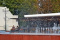 Fountain jets on the background of a coffee shop with tables Royalty Free Stock Photo