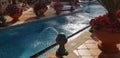 Fountain jets into the water canal of blue outdoor swimming pool Royalty Free Stock Photo