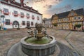 Fountain made of copper in the middle of the old marketplace with half-timbered houses and the town hall in the background in Linz