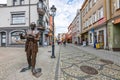 A fountain on the market square in a small town. Bronze monument in the city center. Summer season.