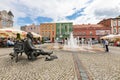 A fountain on the market square in a small town. Bronze monument in the city center. Summer season.