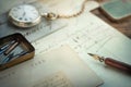 Fountain nib pen, envelope, postcard, clock and letter are on the table. Vintage vintage background on the theme of history,