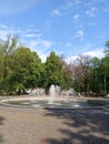 fountain in the park, leaves, green, white clouds on the blue sky, for postcards, business cards