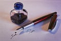 Fountain pen, blue ink and inkwell on white paper sheet Royalty Free Stock Photo