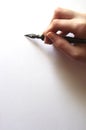 Fountain pen in hand on blank white paper with copy space Royalty Free Stock Photo