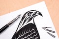 Fountain pen with ink drawing hawk.