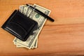 Money clip and one hundred dollars banknotes on wooden table Royalty Free Stock Photo