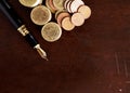 Fountain pen and Money coins stack on wooden table for finance c Royalty Free Stock Photo