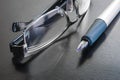 Fountain pen next to a pair of reading glasses