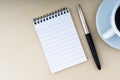 Fountain pen, notepad and cup of coffee on wooden background Royalty Free Stock Photo