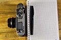 Fountain pen, old camera, and notebook on wooden table Royalty Free Stock Photo