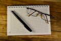 Fountain pen, old camera, and notebook on wooden table Royalty Free Stock Photo